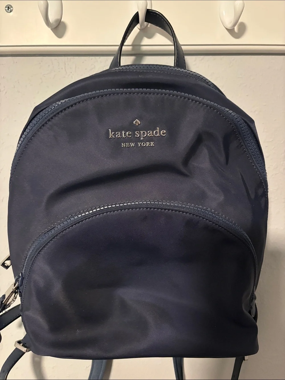kate spade navy blue woman’s  backpack with silver logo